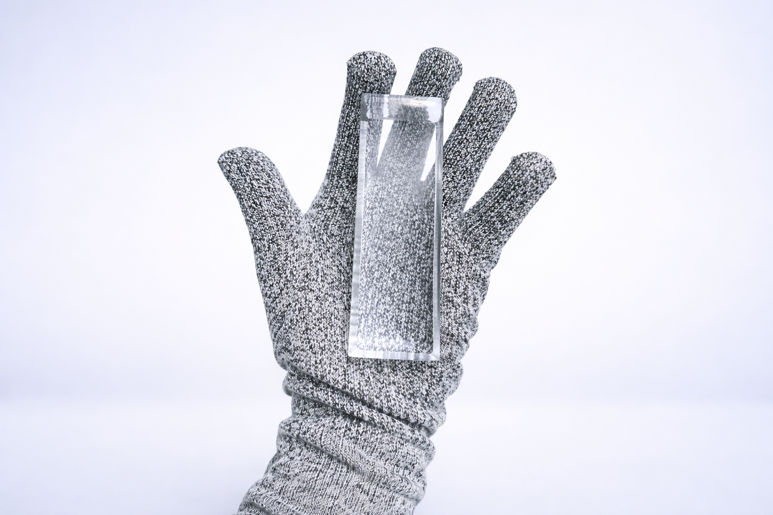 Gloved hand holding a clear ice stick
